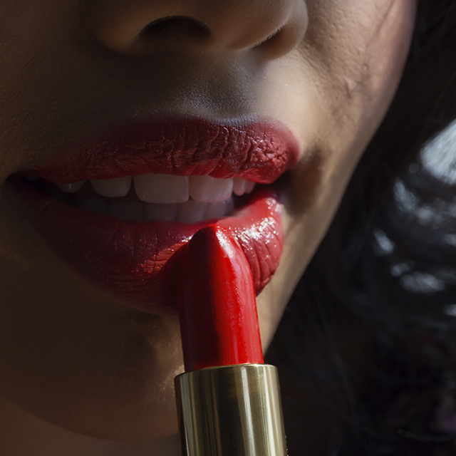 Jeune femme se mettant du rouge à lèvres (Istock)