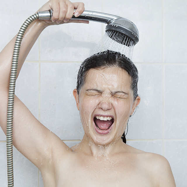 Femme passant la tête sous l'eau froide et semble peu apprécier (Istock)